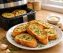 Crispy golden air fryer garlic bread slices on a white ceramic plate, glistening with garlic butter and sprinkled with fresh parsley