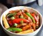Air fryer Chinese stir-fry with chicken, pork, red pepper, and baby corn in glossy sauce, served in white ceramic bowl
